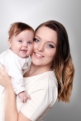happy family at home. Mother holding baby in bedroom in cozy weekend morning