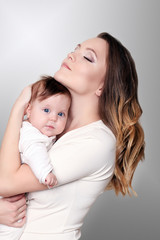 newborn baby in a tender embrace of mother at the window