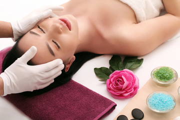 Cute relaxed young woman laying in spa salon with closed eyes