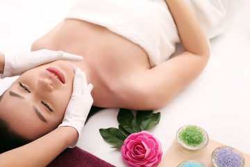Obraz na płótnie Canvas Beautiful young woman receiving facial massage in spa salon