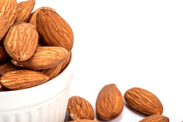 the fresh almonds in white cup on white background