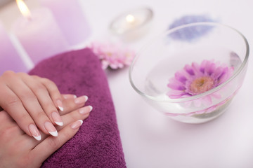 Closeup shot of a woman in a nail salon receiving a manicure by a beautician with cotton wool with acetone. Woman getting nail manicure. Beautician file nails to a customer