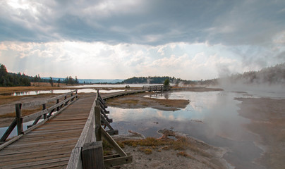 Boardwalk next to Tangled Creek and Black Warrior Springs leading into Hot Lake in the Lower Geyser Basin in Yellowstone National Park in Wyoming United States