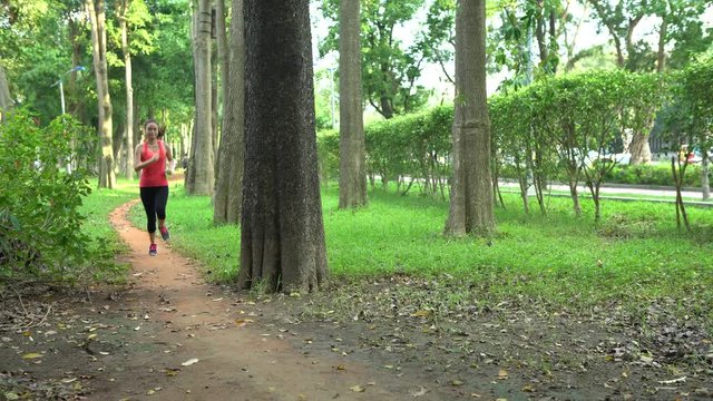 4K Runner running woman jogging in Taipei city Daan park. Exercising Asian People Run on the path, living healthy active lifestyle in Taiwan. Slider Camera Movement -Dan