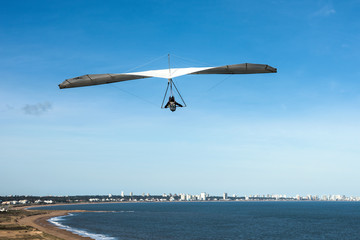 Hang-glider flies over the Punta Ballena cape, Punta del Este, Uruguay