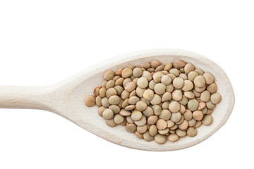 Green lentils on wooden spoon isolated on white.