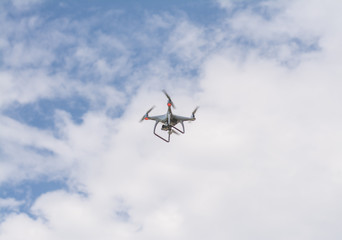white drone hovering in a bright blue sky