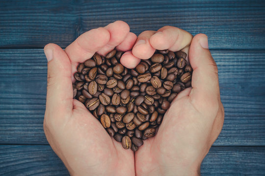 Male Hands Holding Coffee Seeds In Heart Shape Symbol Of Love.