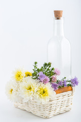 Colorful flowers in the wooden bucket on the white background