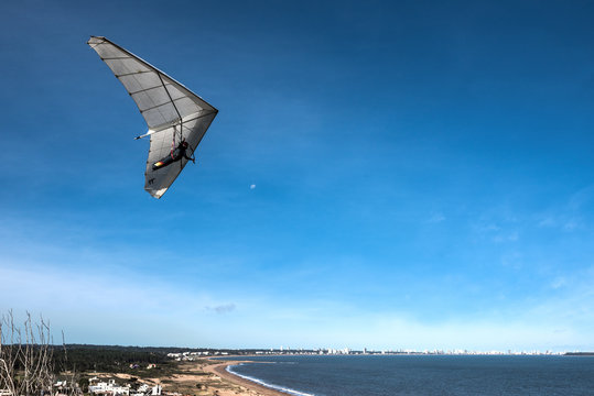 Hang-glider flies over the Punta Ballena cape, Punta del Este, Uruguay