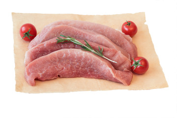 Pieces of raw pork with tomatoes on paper isolated on white background.