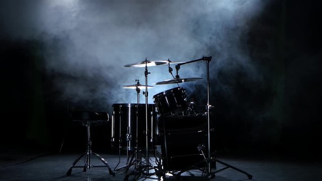 Set of drums, cymbals and other percussion instruments. Black smoky background.