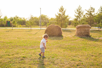 Naklejka na ściany i meble Summer, childhood and baby concept - little boy having fun in summer nature