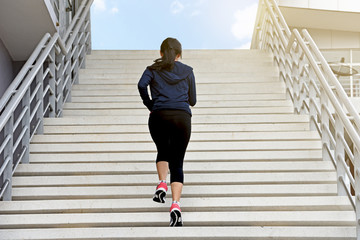 Young exercise woman running alone up stairs - 166939810