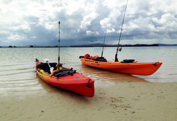 Kayaks at sunset with an approaching storm, far north NZ 