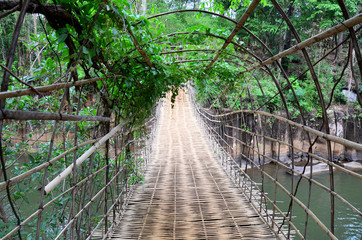 Fototapety  Wiszący drewniany i bambusowy most do przeprawy przez rzekę potok przy wodospadach Tad Pha Suam