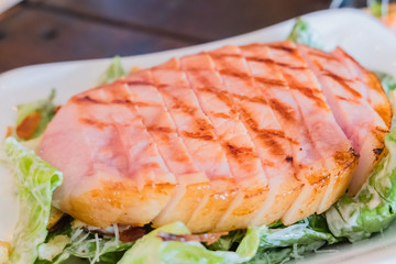 Grilled  pork steaks and vegetable salad on the plate .