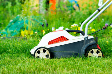 electric lawn mower on green grass