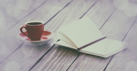 Cup of coffee and notebook with pencil