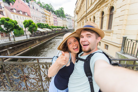 Happy romantic couple of tourists makes selfie self-portrait in Karlovy Vary while traveling across Europe.