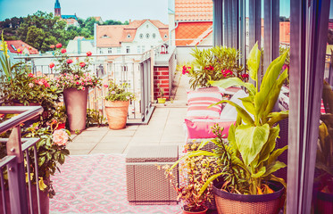 Pretty summer terrace or balcony of  penthouse with flowers patio pots ,  outdoor furniture and...