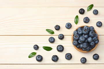 Naklejka na ściany i meble blueberries in wooden bowl on light wooden table background. top view with copy space