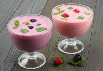Healthy raspberries and blackberries yogurt with fresh berries on dark wooden background