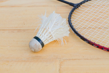 used shuttlecock and badminton racket on wooden background