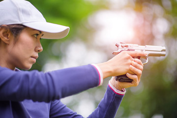 woman in practice shooting gun in martial arts for self defense in an emergency case