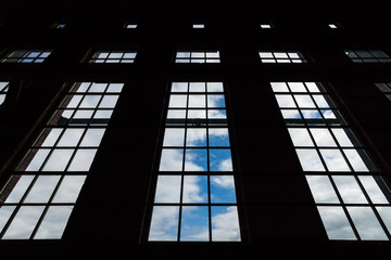 The sky through the large panoramic windows of an abandoned building.
