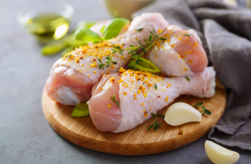 Fresh raw chicken legs with spices - salt, pepper, olive oil and garlic. Close up