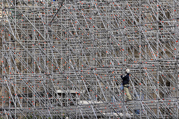 A worker on a scaffold working on a building construction