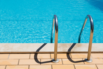 Stainless steel steps leading into swimming pool