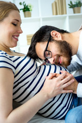 Father kissing pregnant belly