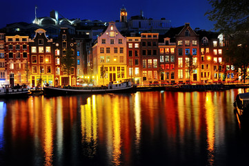 Scenic view of Amsterdam canal and buildings at night, Netherlands