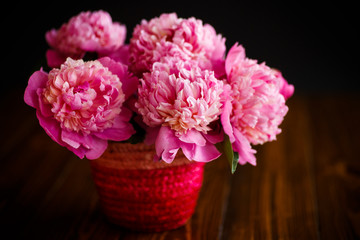bouquet of pink peonies in a wicker vase