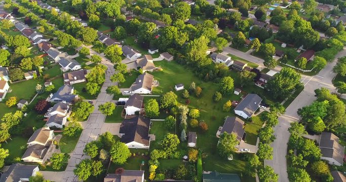 Beautiful neighborhood in summer at sunrise, moving aerial view.
