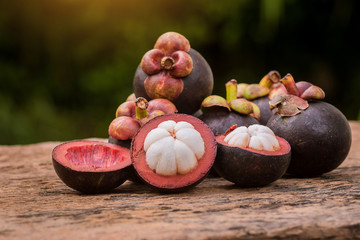 fresh mangosteen fruit laying on wood background. close up