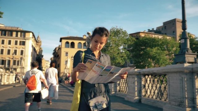 Young Woman Tourist Checks Map on Castel Sant'Angelo Bridge in Rome