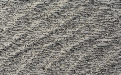 Gray textured natural stone with a diagonal wave pattern.