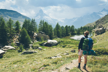 Man hiking to Matterhorn Mountain with white snow and blue sky in Zermatt city in Switzerland.
