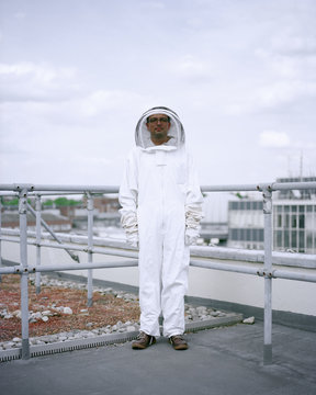 A bee Keeper stands among the rooftops of central London 