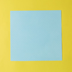 blue paper polka dots on a yellow. fashionable texture background