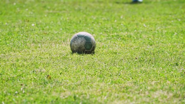 Soccer field, football player hits the ball.
