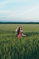 Beautiful young woman at sunset in the field