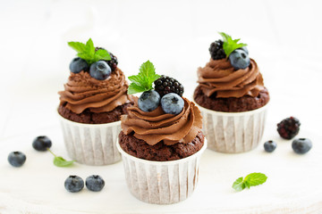 Chocolate cupcakes, with chocolate cream and fresh berries.
