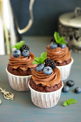 Chocolate cupcakes, with chocolate cream and fresh berries.