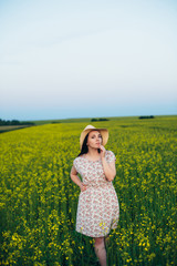 Fototapeta premium Beautiful young woman at sunset in the field