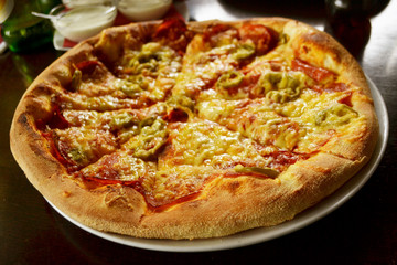 whole italian pizza on wood table with ingredients