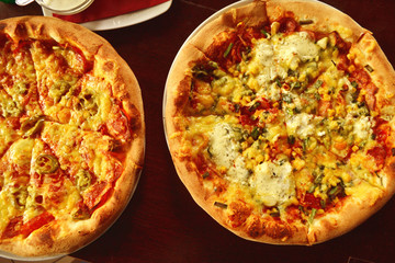whole italian pizza on wood table with ingredients